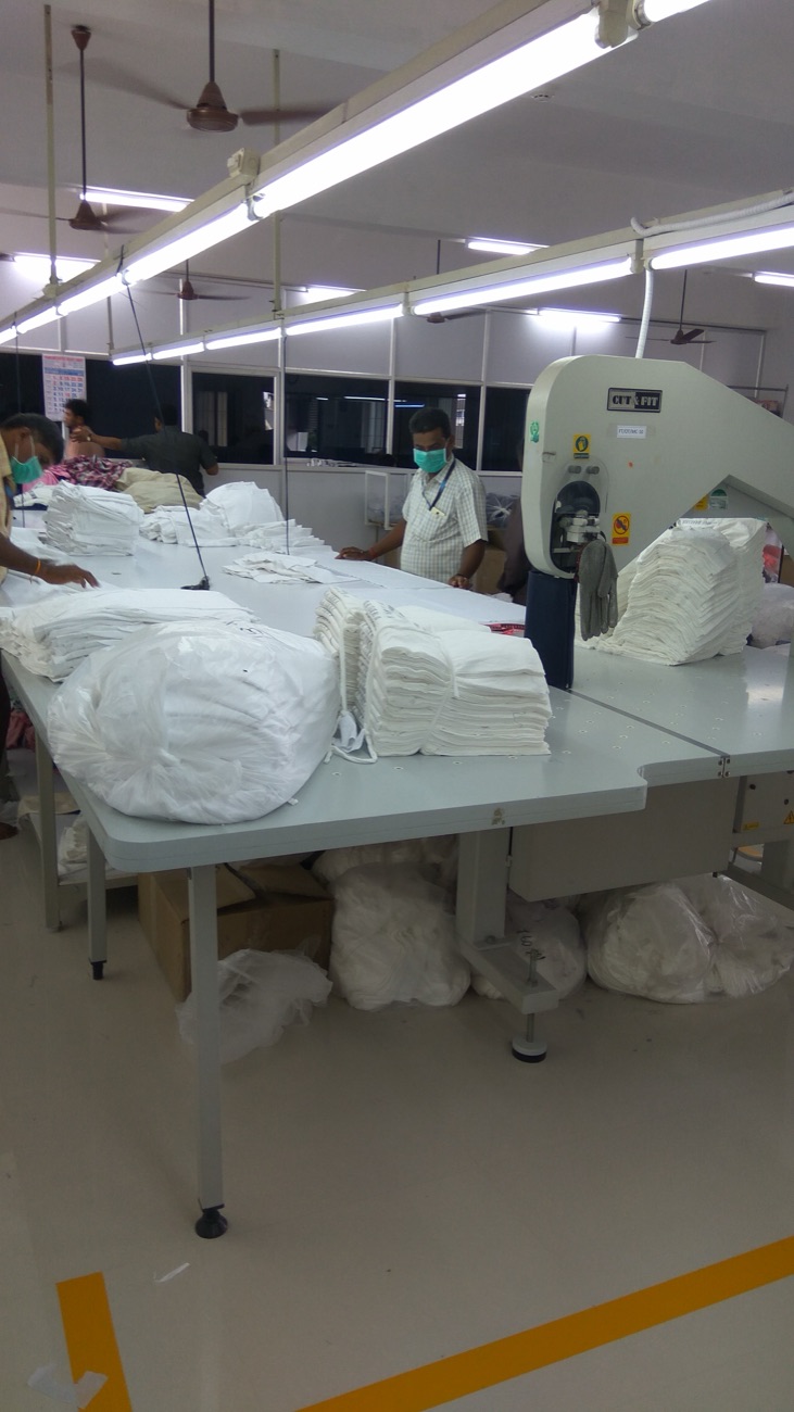 Fabric plies laid up on the cutting table at Fabro, with cut bundles stacked ready for the lines